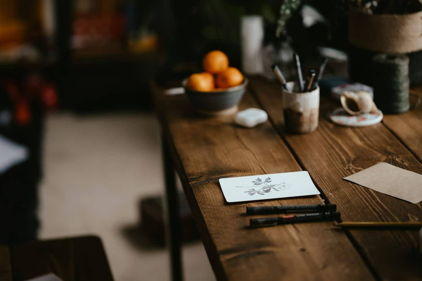 Creatieve werkplek met botanische tekening, pennen en knutselspullen.